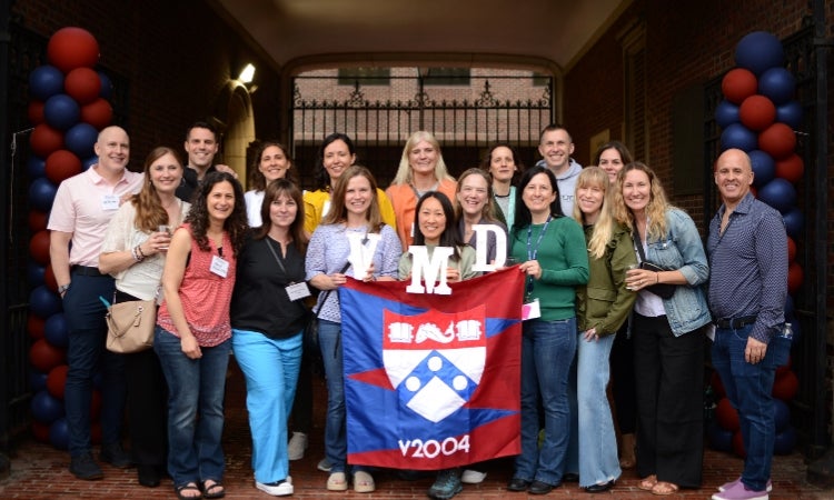 a group of people posing for a picture in front of a banner